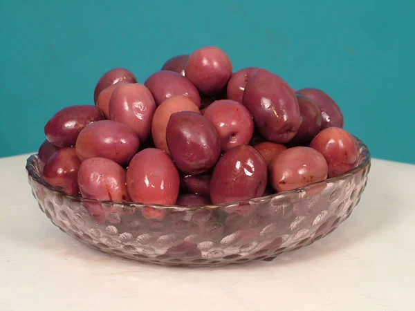 Olives tournantes roses et violettes tailladées — photographie du catalogue Triffa Conserves